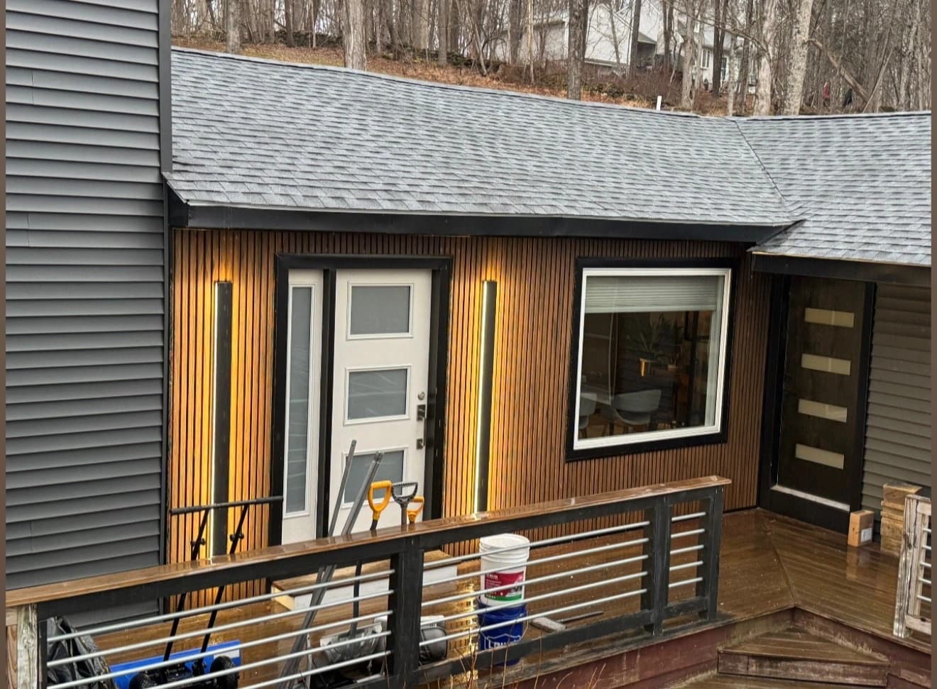 Modern home entrance with vertical wood slat wall and integrated warm LED lighting during construction